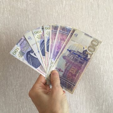 Hand Holding Georgian Lari Banknotes on Neutral Background