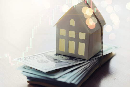 House model and Money, house key lying on real estate contract, home loan and investment concept.