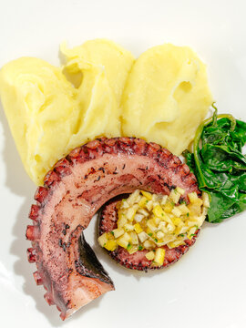 grilled octopus with side dish on a plate