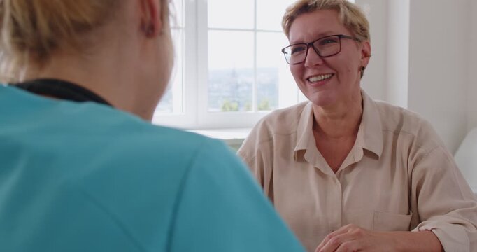 Patient and doctor discuss care during consultation. In a bright clinic office, a senior asks questions during a healthcare appointment. Supportive advice and discussion improve communication.