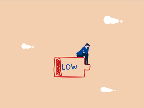 businessman sat dejectedly on a battery with low charge.