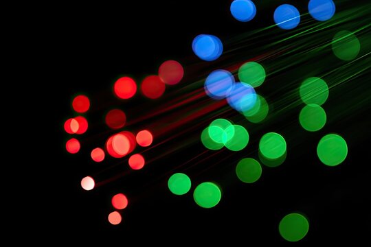 A vibrant display of blurred, colorful lights against a dark background creates an abstract and dynamic visual effect.