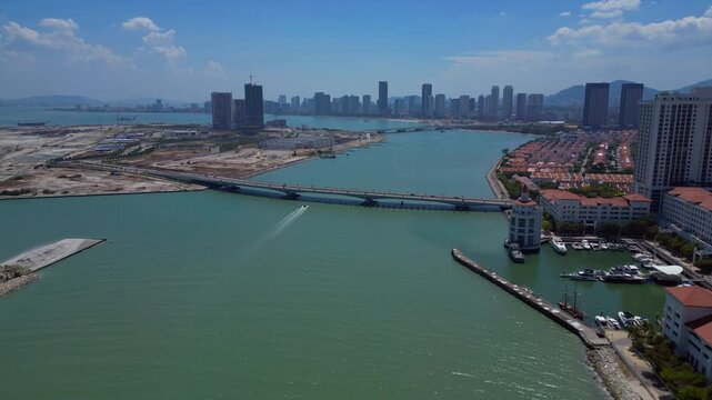 Kuala Juru river bridge connecting land reclamation and residential area with Georgetown city skyline and hills in background. Best aerial view drone shot panorama from above