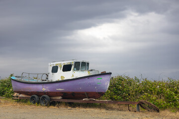 Fototapeta premium Purple abandoned fishing boat on a trailer