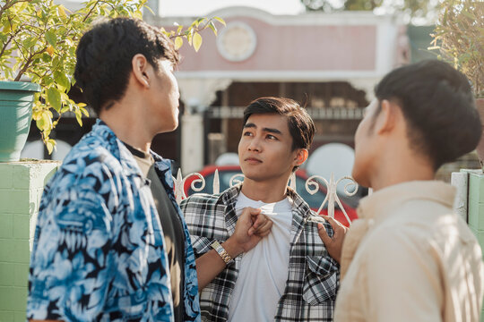A tense young Asian men confronting their friend over a money scam as emotions rise during a heated outdoor argument. Outdoor shot.