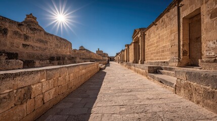Fototapeta premium Sunlit Ancient Stone Alleyway of Historic European Architecture Under a Clear Blue Sky