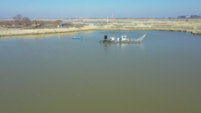 Mixture water and sand flow from big pipe, pump discharge for sand sedimentation. Water flows and carries sand from opencast surface mining, excavating sand and his deposition.