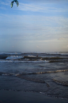 Kitesurfer riding waves on windy day at Batu Bolong Beach, Canggu