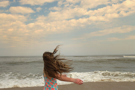 Profile young girl long hair blowing playing at Cape Hatteras Na