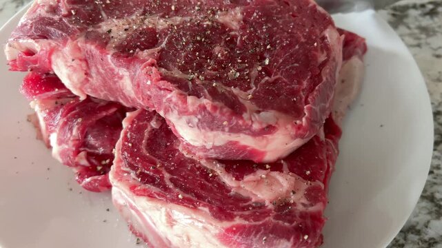 Stack of Raw Ribeye Steaks in Kitchen Light