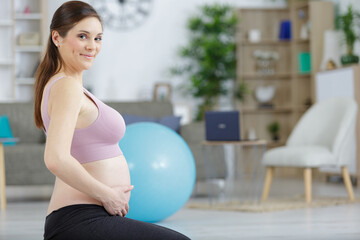 Naklejka premium pregnant woman at home with fitness ball doing relaxation exercises