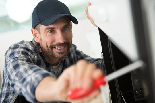 a man repairing a microwave