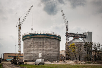 Obraz premium Building cranes at construction site. Construction building process of new silo. Industrial theme
