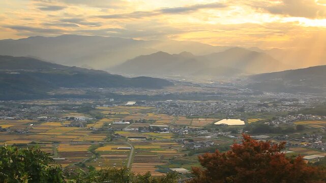 祢津城跡から望む美ヶ原方向の山並みと夕日の光芒と上信越道