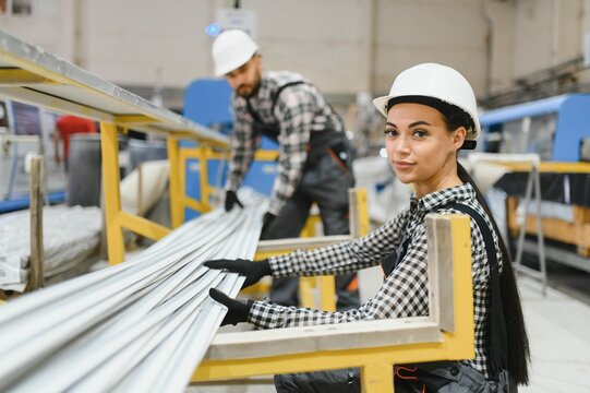 Factory workers handling pvc profiles for window and door production