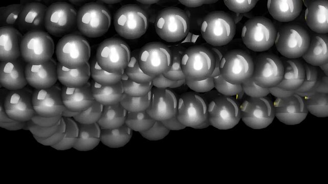 Metallic silver spheres packed tightly together in a reflective grid formation representing industrial manufacturing and precision engineering material science