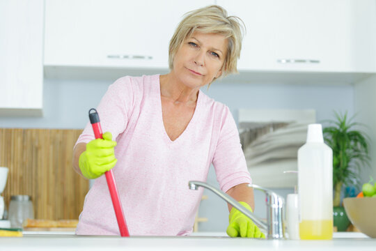 senior woman cleaning a kitchen sink