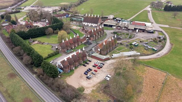 Hop farm in Tonbridge Kent aerial view flying over British A road towards rustic oast houses