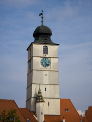 Fototapeta premium Council Tower of Sibiu (Turnul Sfatului) with its copper-domed roof and large clock face standing against a blue sky in Sibiu, Transylvania, Romania.