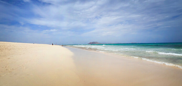 White sand beach and turquoise ocean water under cloudy sky