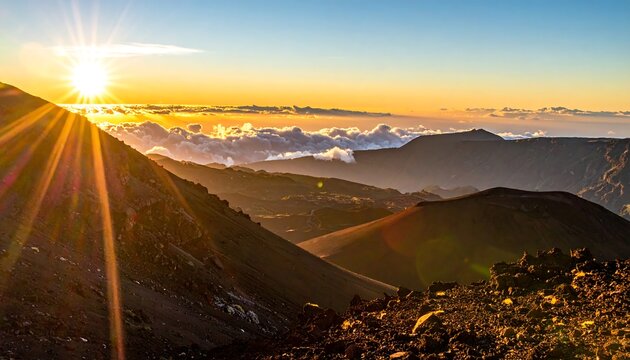 Mountainous landscape at sunrise; sunburst rays shine over peaks and clouds