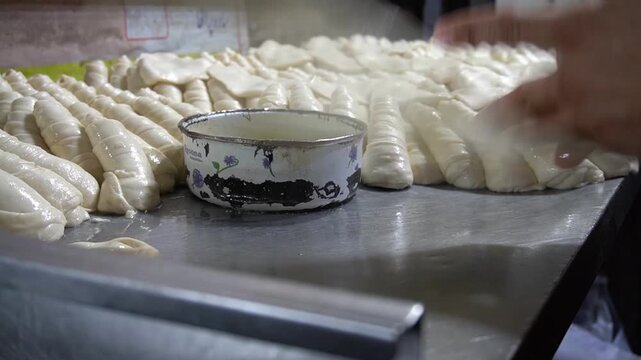 Hands shaping paratha dough, traditional preparation with soft lighting, homemade cooking concept