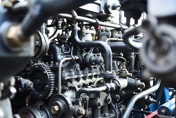 Fototapeta premium A heavily detailed engine, likely from a large vehicle, with numerous belts and pulleys. It appears to be in a workshop or garage setting.