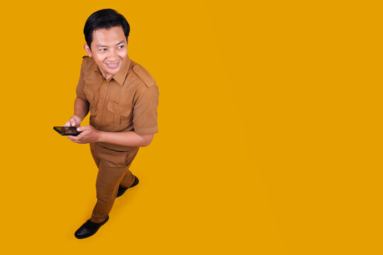 Indonesian Male Civil Servant in Khaki Uniform Holding Smartphone and Looking Back