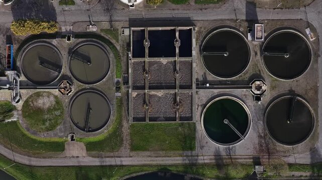 Aerial view of circular water treatment plant with a series of tanks and pools creating a geometric pattern, Lisbon, Portugal.