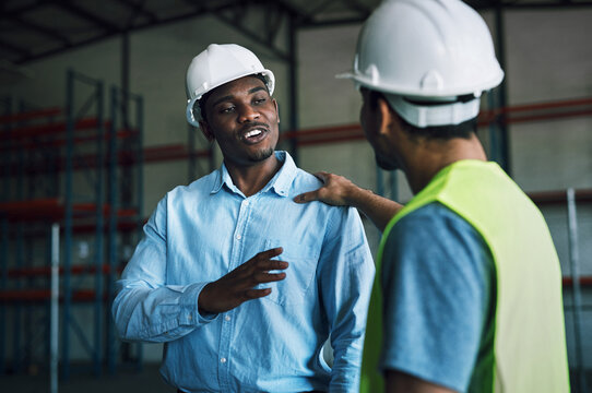 Businessmen, contractor and conversation with colleague in warehouse for storage safety or control. Male people, employees or engineers talking for social discussion or chat in supply chain depot