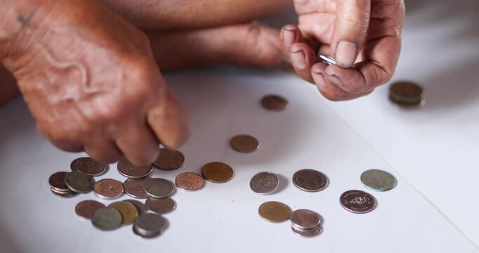 Hands counting Thai coins, symbolizing saving, personal finance, limited income, budgeting, and everyday expense management, close-up