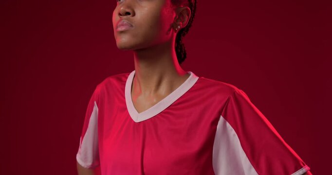 African American woman posing camera pulling up tilting meeting gaze making studio promo red jersey