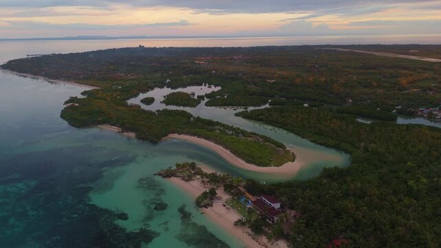 Aerial view of a hidden tropical lagoon on Bantayan Island, Philippines. The drone captures the crystal clear turquoise water surrounded by limestone rocks and lush coastal greenery