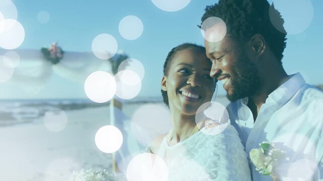 Bride and groom sharing smiles while groom placing arm, drifting bokeh revealing faces, wedding