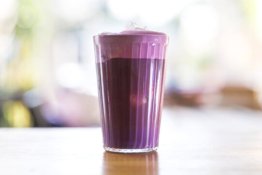 A refreshing ube iced coffee served in a clear glass