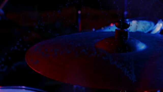 Vertical video: Offscreen stick striking cymbal, cymbal streaking then decaying in lights for music