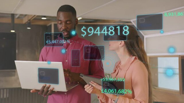 Tapping laptop, pair lifting tablet activating financial HUD displaying $944,818 reviewing revenue