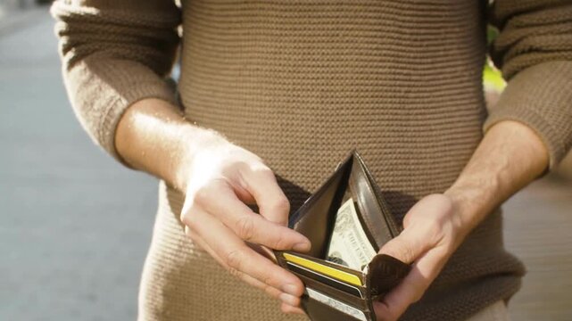 financial crisis money loss broke man with empty wallet with the last dollar bills and penny coins