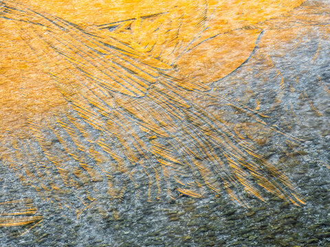 Abstract background. Yellow paint streaks on a gray surface create a textured pattern.