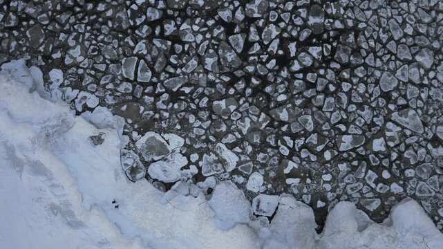 Aerial view of the frozen Baltic sea showing a stark contrast between the white icy land and the dark frozen waters, Mikoszewo, pomorskie, Poland.