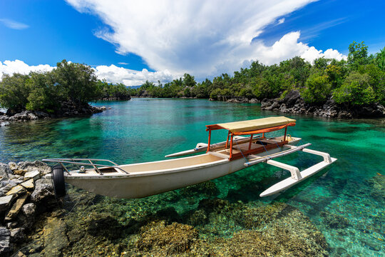 Traditional Outrigger Boat on Crystal Clear Turquoise Water at Doro Solola, Tobelo, North Halmahera