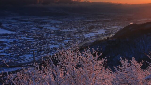 小牧城から望む着雪した樹林と烏帽子岳などの山並みと朝日