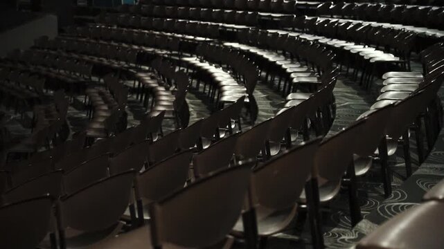 Dark auditorium with rows of empty chairs