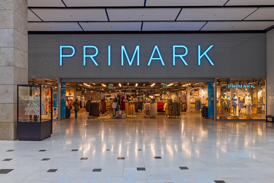 Utrecht, Netherlands, April 2, 2026. The wide entrance of a Primark retail fashion store featuring the illuminated blue brand name inside a shopping center.