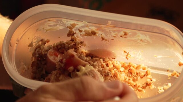 Buckwheat eating spoon, person enjoys casual food from plastic container at home