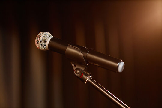 Close up of stage microphone standing for standup performance, podcast recording, or public speaking. Supporting comedy promotion, live event marketing, entertainment branding use
