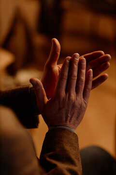 Vertical shot of middle aged man clapping during standup performance on stage, showing audience engagement and live entertainment response. Useful for comedy event promotion and ticket marketing
