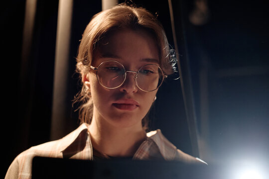 Close up of Caucasian young adult woman performing standup on stage, reading script with focused expression. Useful for comedy promotion, live event marketing, entertainment branding
