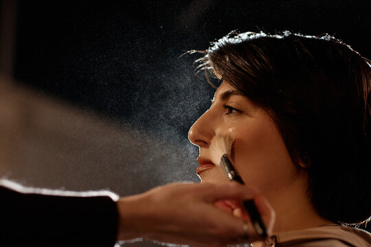 Close up of middle aged Caucasian woman receiving makeup before stage standup performance. Supporting beauty prep, entertainment promotion, backstage production marketing
