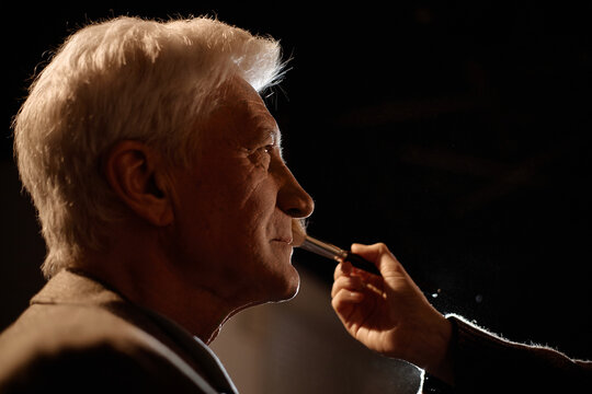Close up of Caucasian senior man receiving makeup before stage performance, preparing for standup appearance. Useful for entertainment promotion, backstage production, live event marketing
